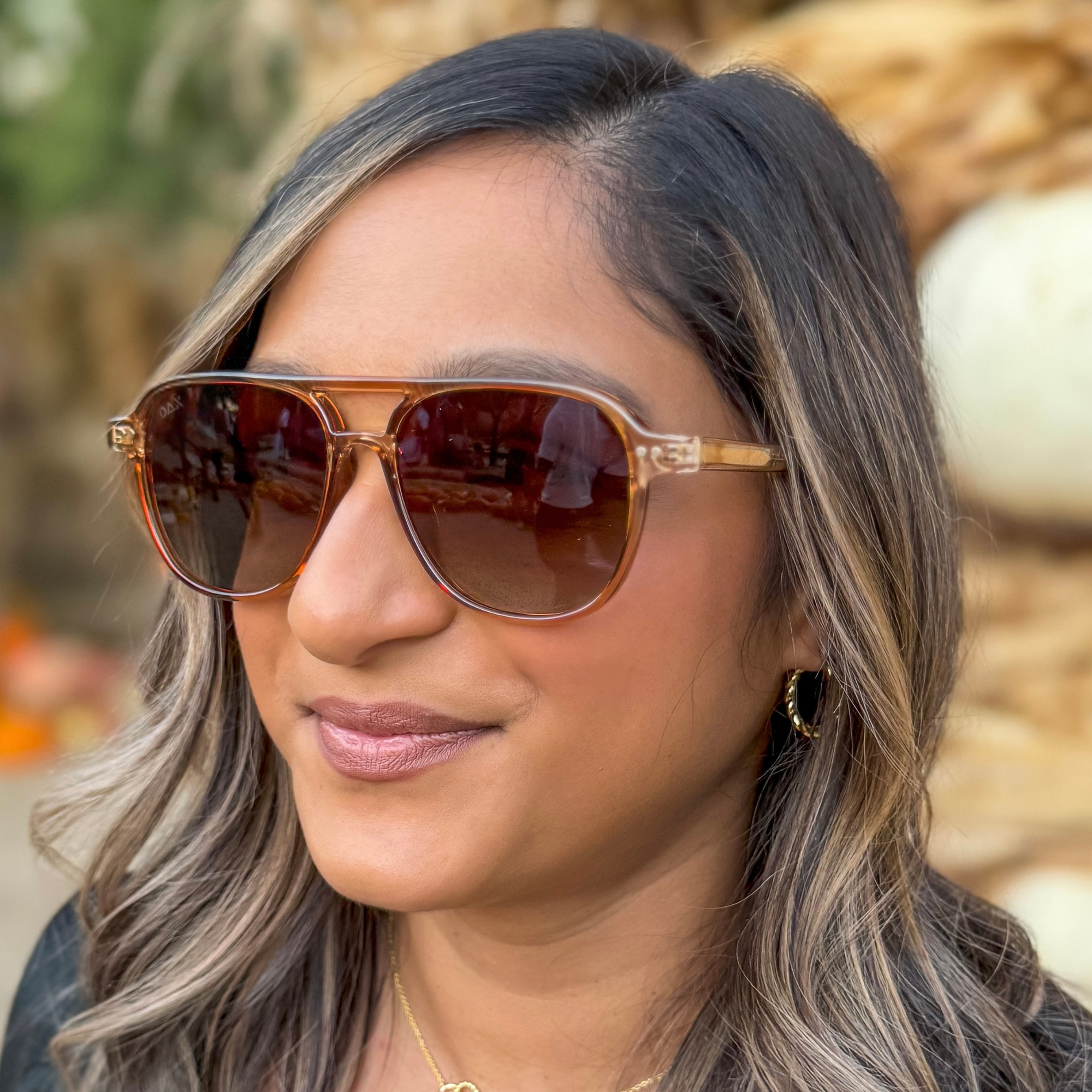 Woman wearing sunglasses with a blurred natural background