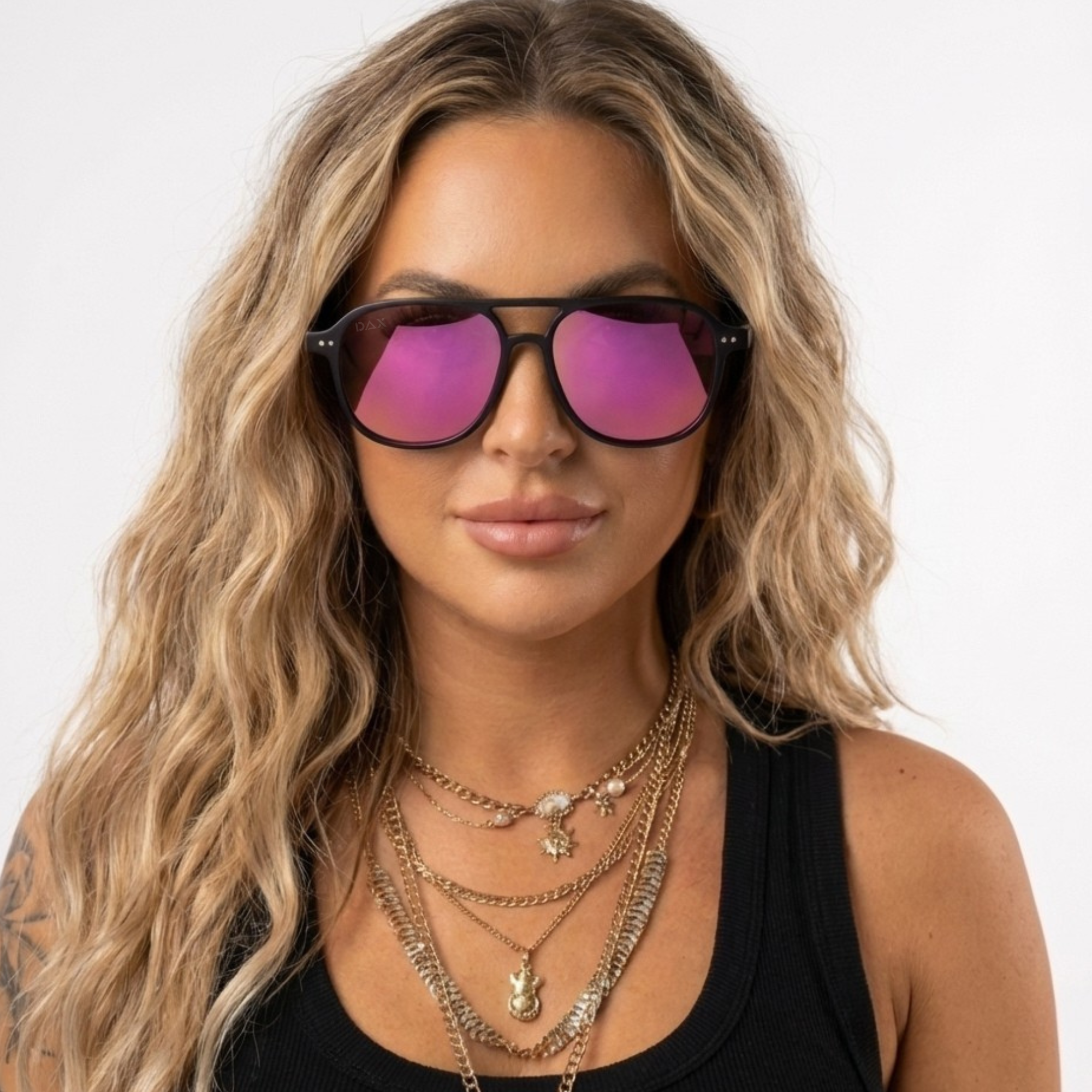 Woman wearing pink-tinted sunglasses with a plain background