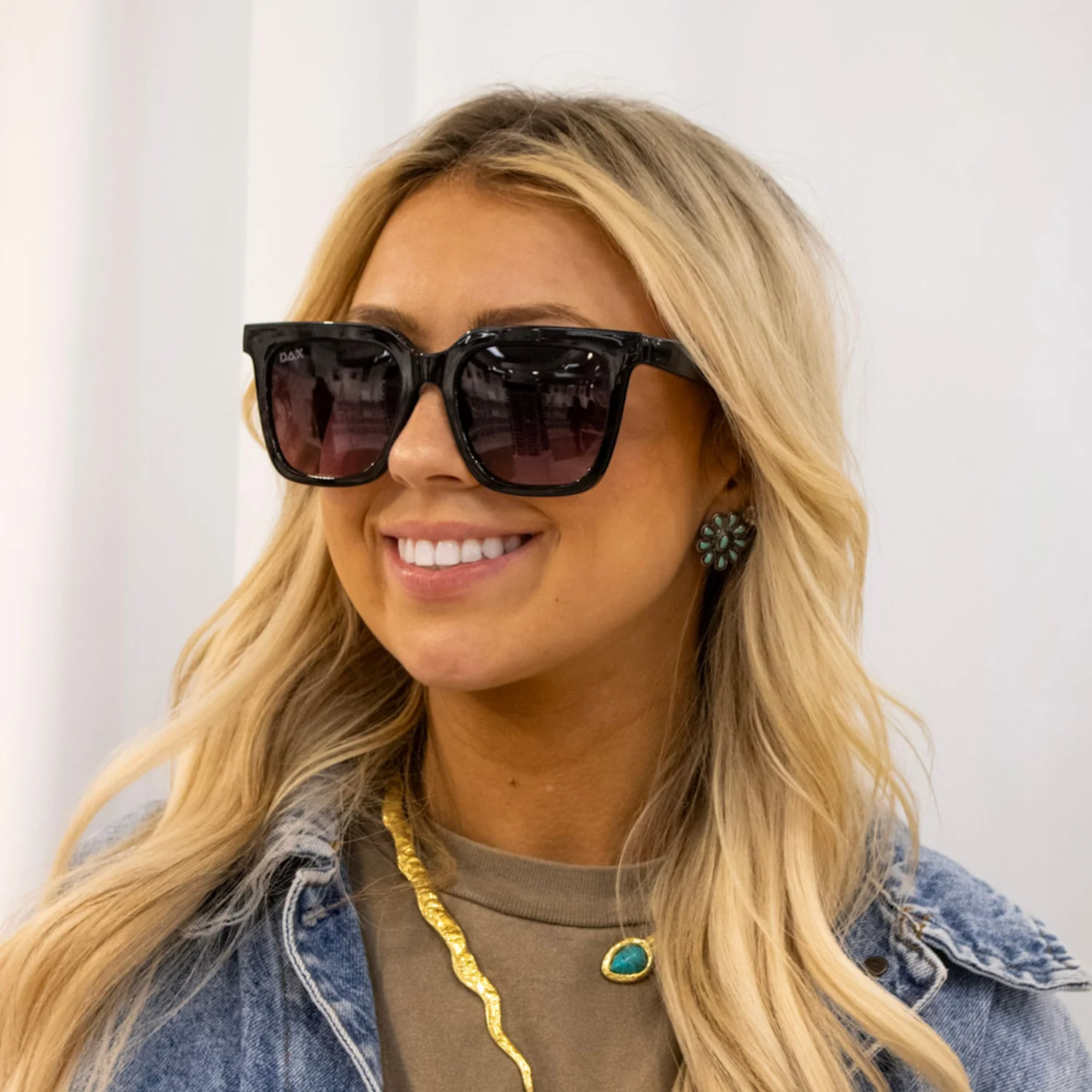 Woman wearing sunglasses with a plain background
