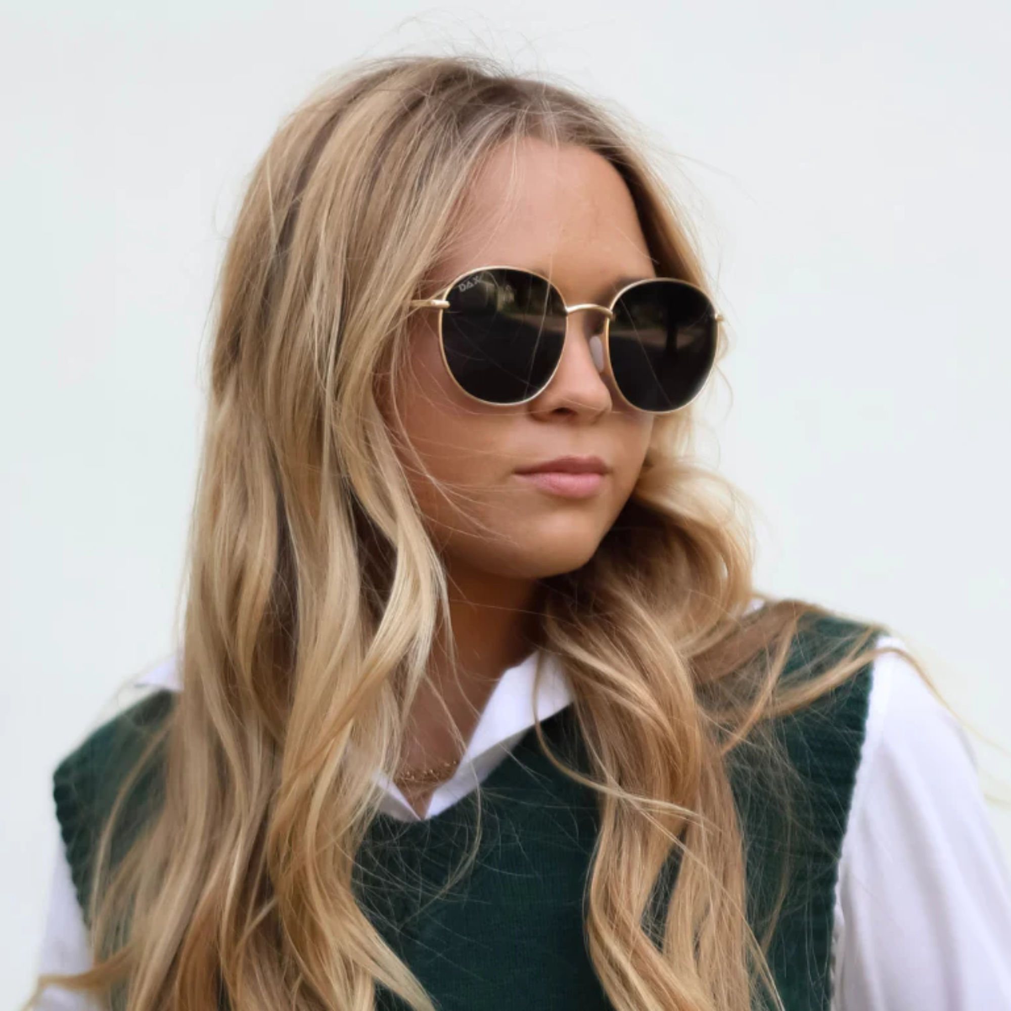Woman wearing sunglasses with a plain background