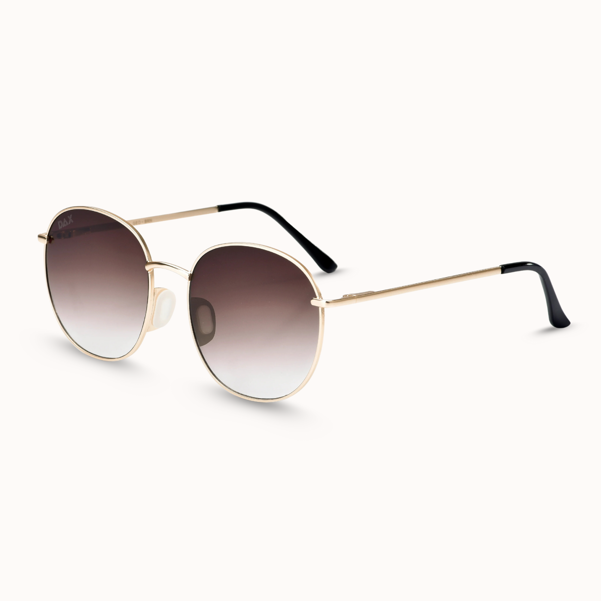Sunglasses with gold frame and gradient lenses on a white background