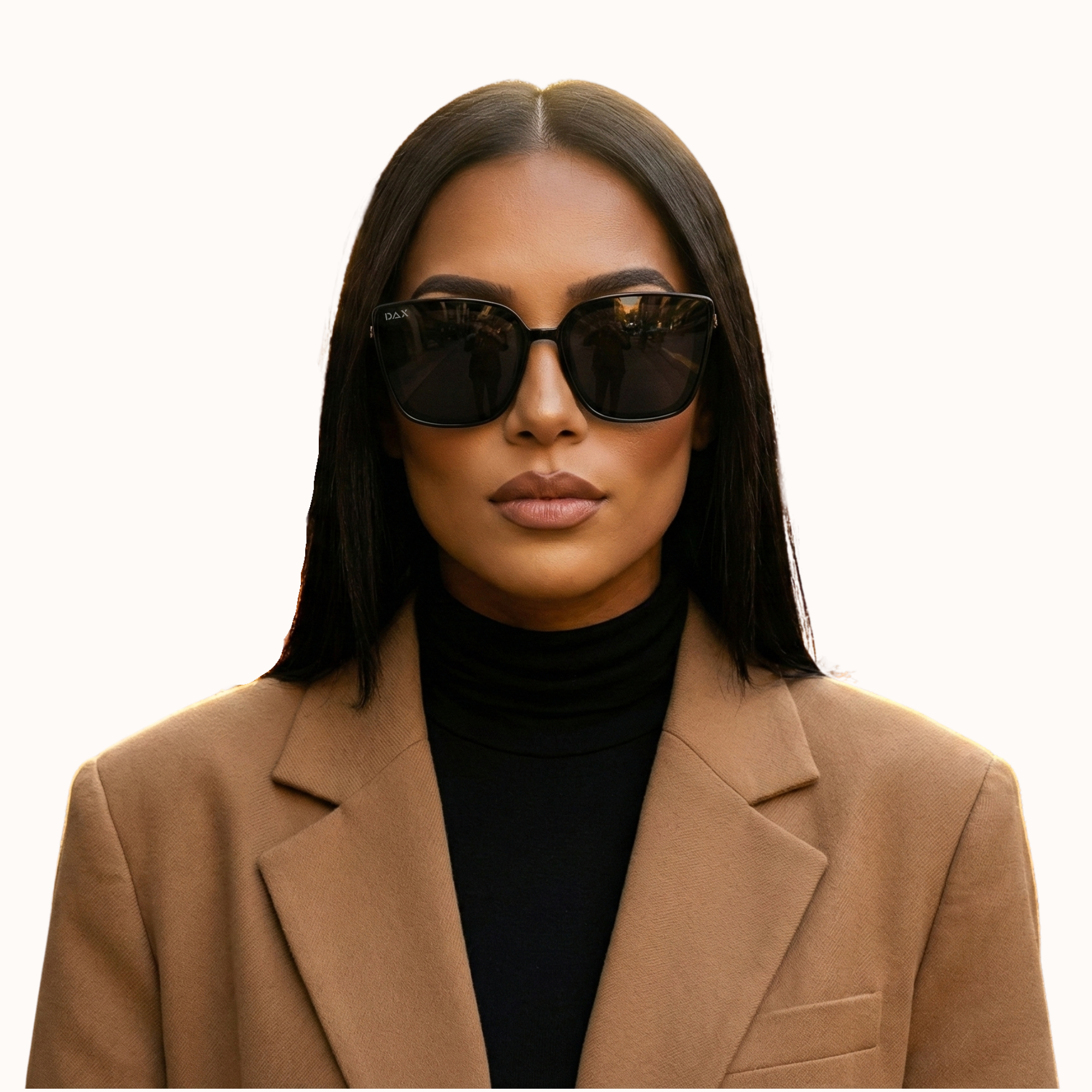 Woman wearing sunglasses and a tan blazer on a white background