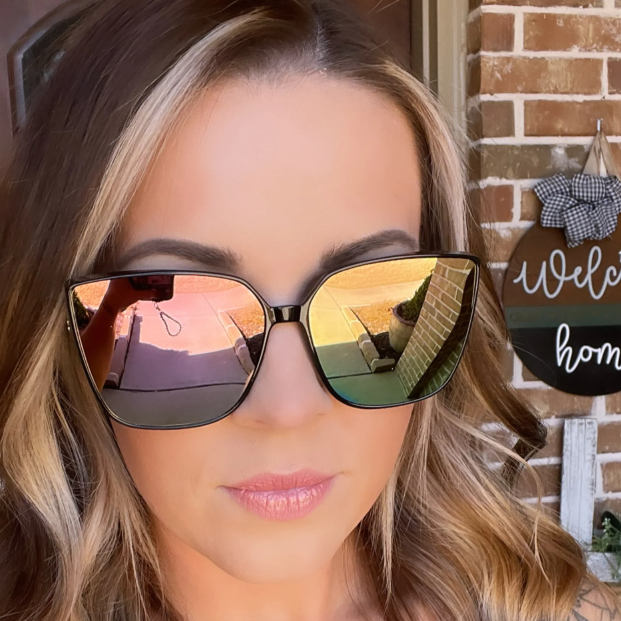 Woman wearing reflective sunglasses with a blurred background