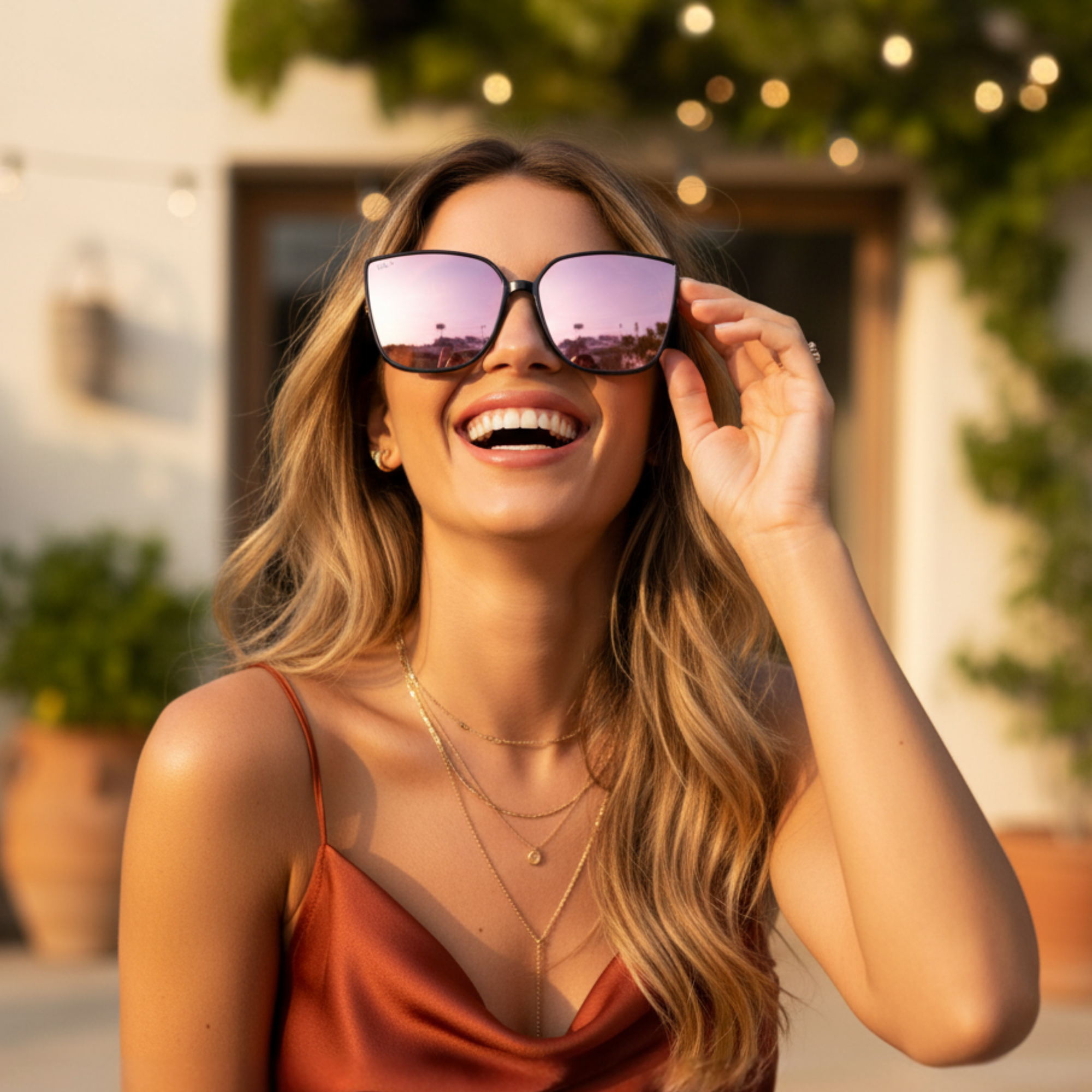 Woman wearing large sunglasses with a blurred outdoor background