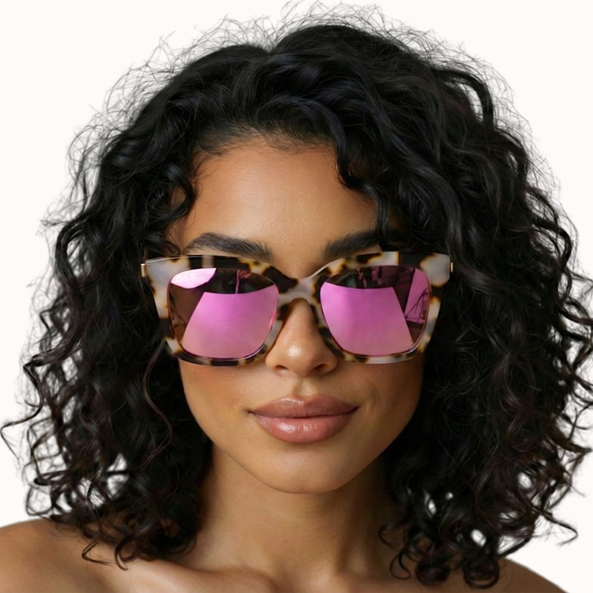 Woman wearing sunglasses with pink lenses and a black frame on a white background