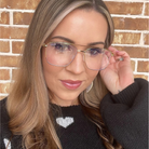 Woman wearing glasses with a brick wall background