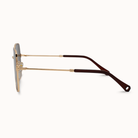 Sunglasses with gold frame and brown arm on a white background