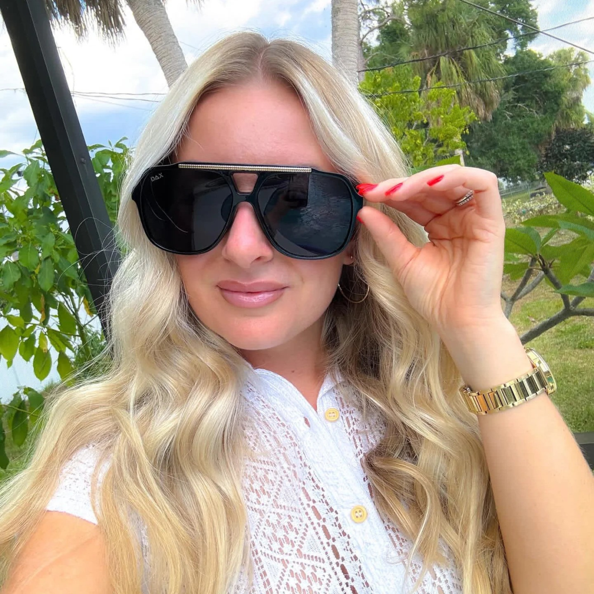 Woman wearing sunglasses with a blurred outdoor background