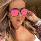 Woman wearing pink sunglasses with a blurred background