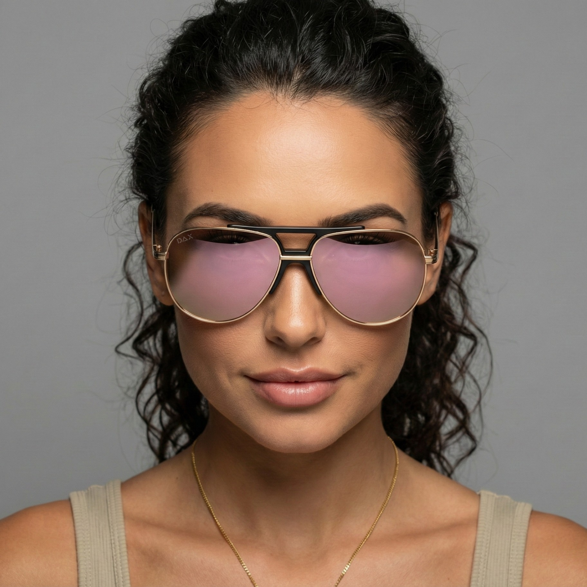 Woman wearing large sunglasses with a neutral background