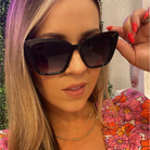Woman wearing large black sunglasses with a blurred background