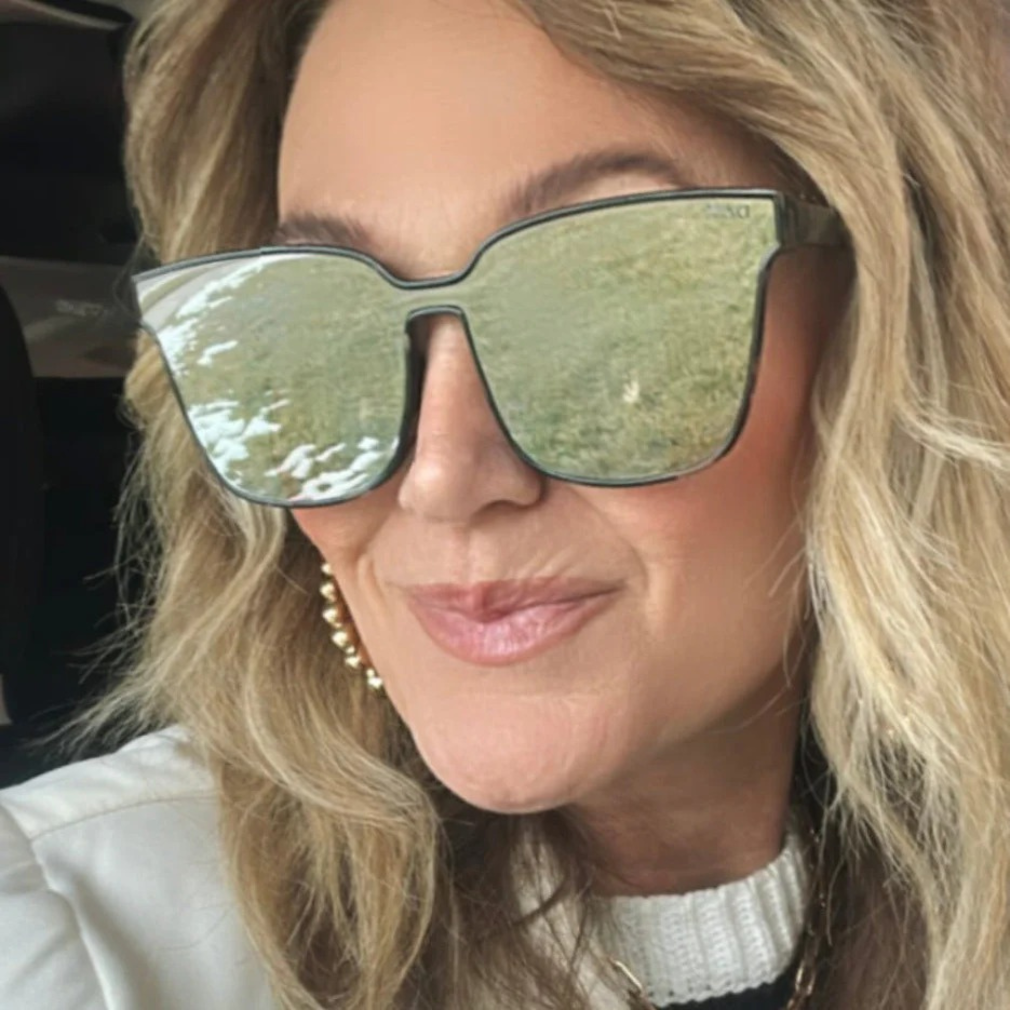 Person wearing large reflective sunglasses with blonde hair.