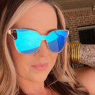 Woman wearing blue reflective sunglasses with a blurred background