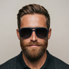 Man wearing dark sunglasses with a neutral background