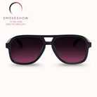 Black sunglasses with dark lenses on a white background, featuring the Smokeshow logo.