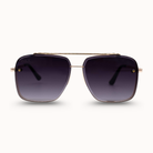 Sunglasses with dark lenses and gold frame on a white background
