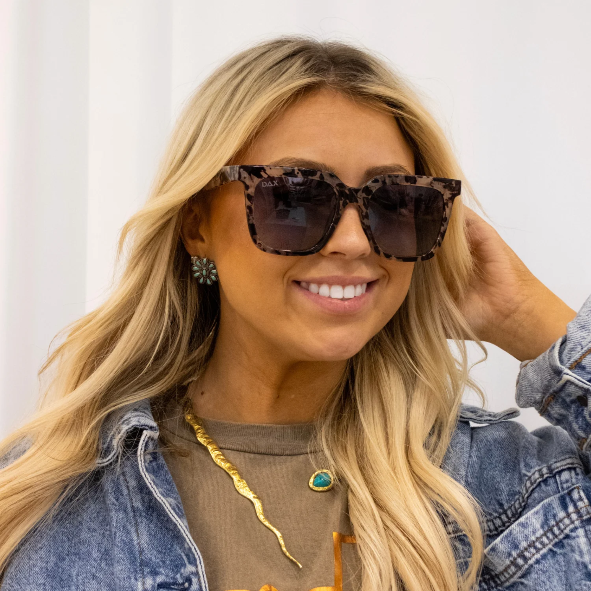 Woman wearing leopard print sunglasses with a neutral background