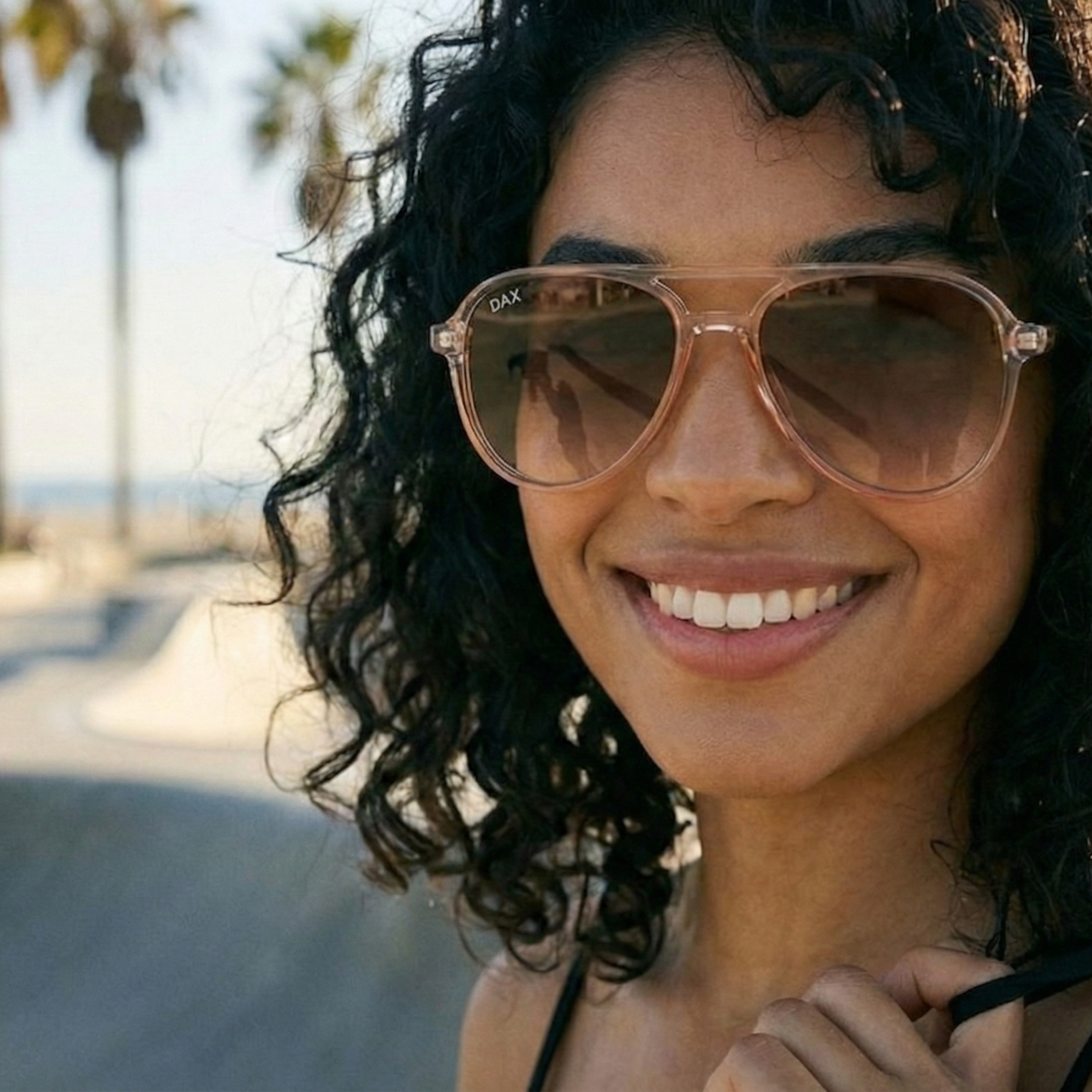 Woman wearing sunglasses with a blurred beach background