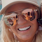 Person wearing reflective sunglasses with a scenic background