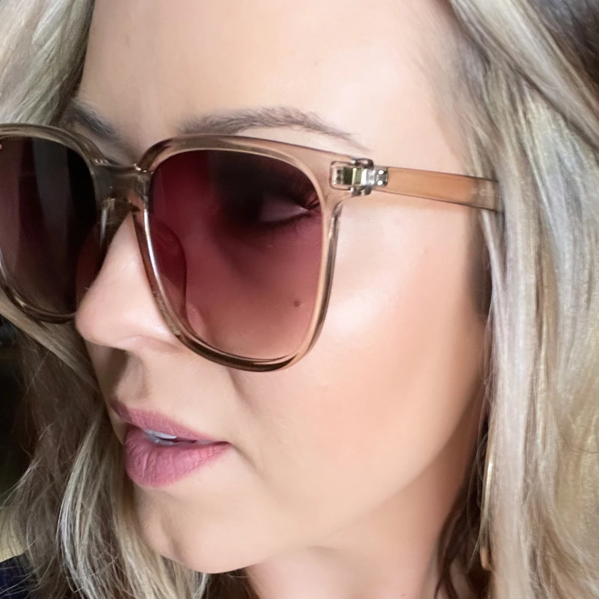 Close-up of a person wearing sunglasses with a neutral background