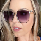 Close-up of a person wearing sunglasses with purple lenses.