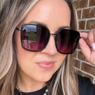 Woman wearing black sunglasses with a blurred background