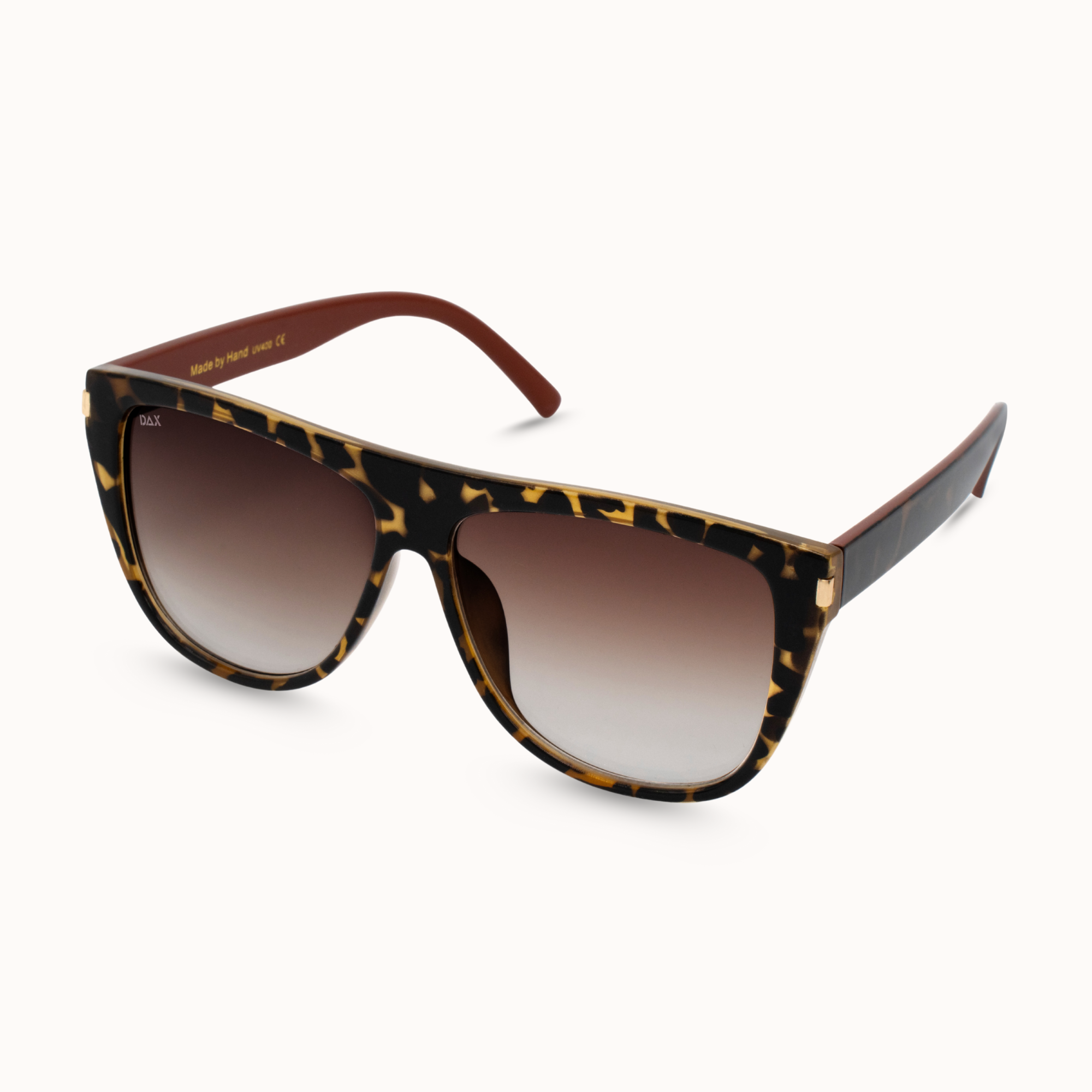 Sunglasses with tortoiseshell frame and brown gradient lenses on a white background