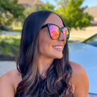 Woman wearing colorful reflective sunglasses with a blurred outdoor background