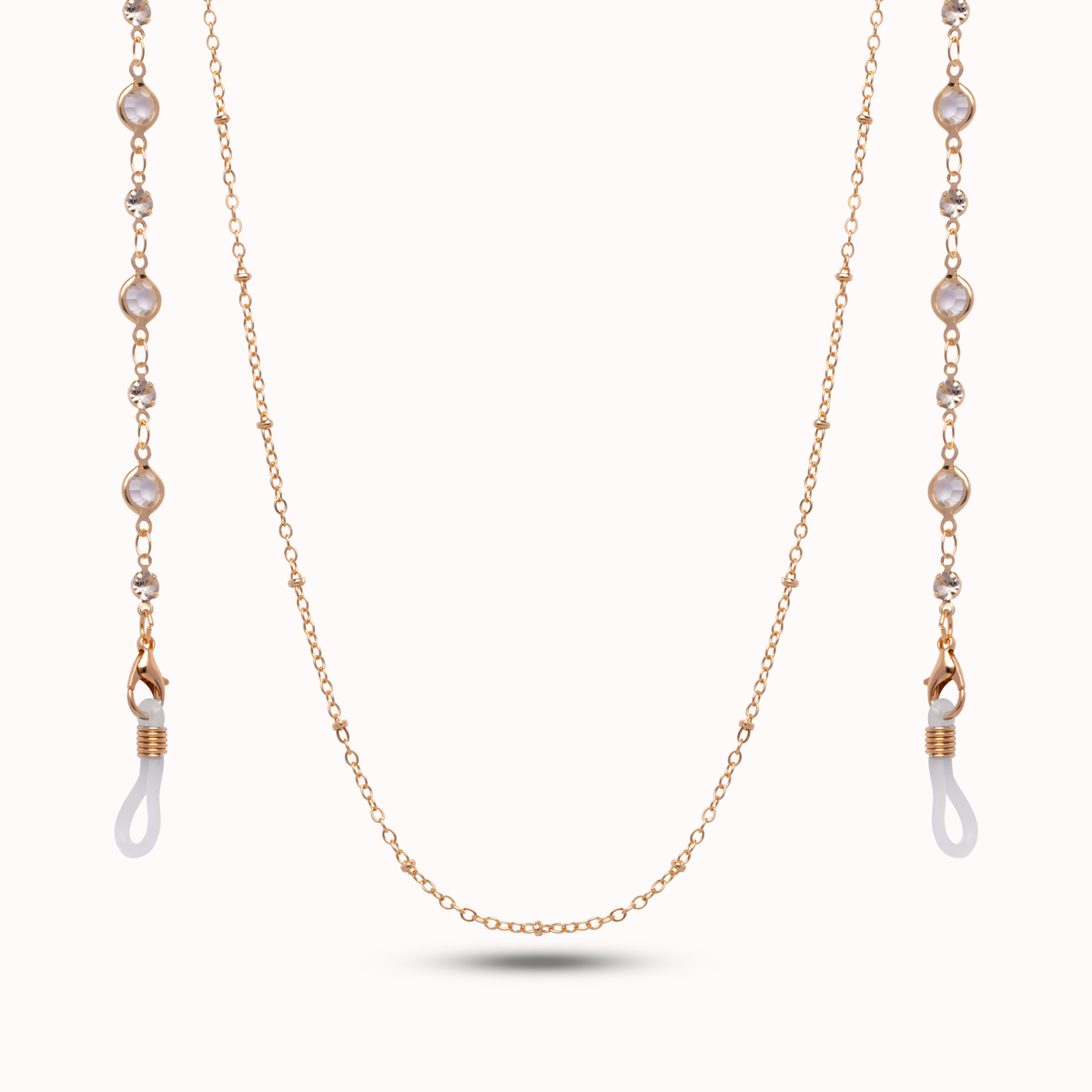 A delicate rose gold chain necklace with pearlescent white bead accents and white silicone ear loops, displayed on a clean off-white background.