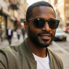 Man wearing sunglasses and a green jacket on a city street