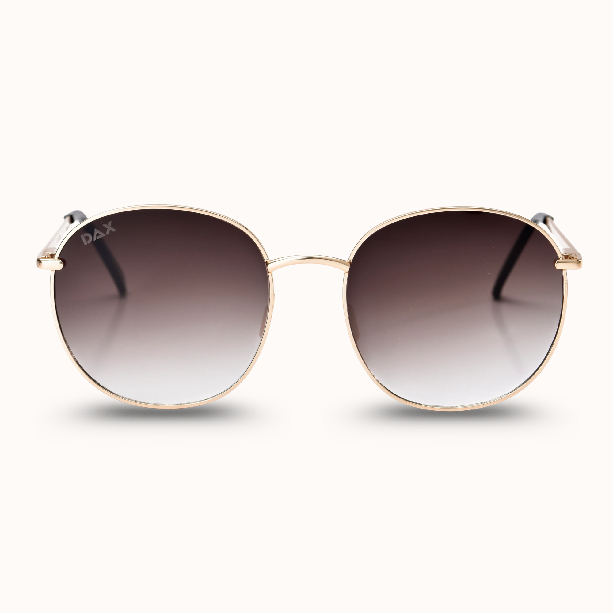 Sunglasses with gold frame and gradient lenses on a white background