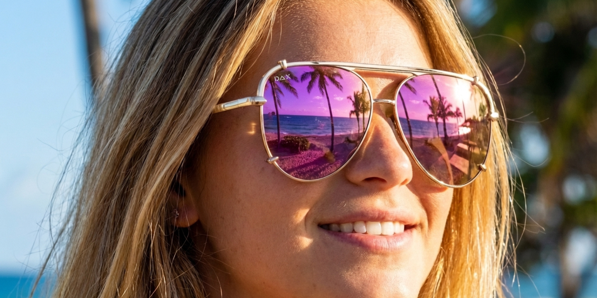 Woman wearing pink-tinted sunglasses with a scenic reflection, outdoors.
