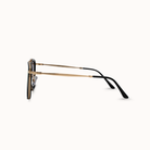 Sunglasses with gold frame and black arms on a white background