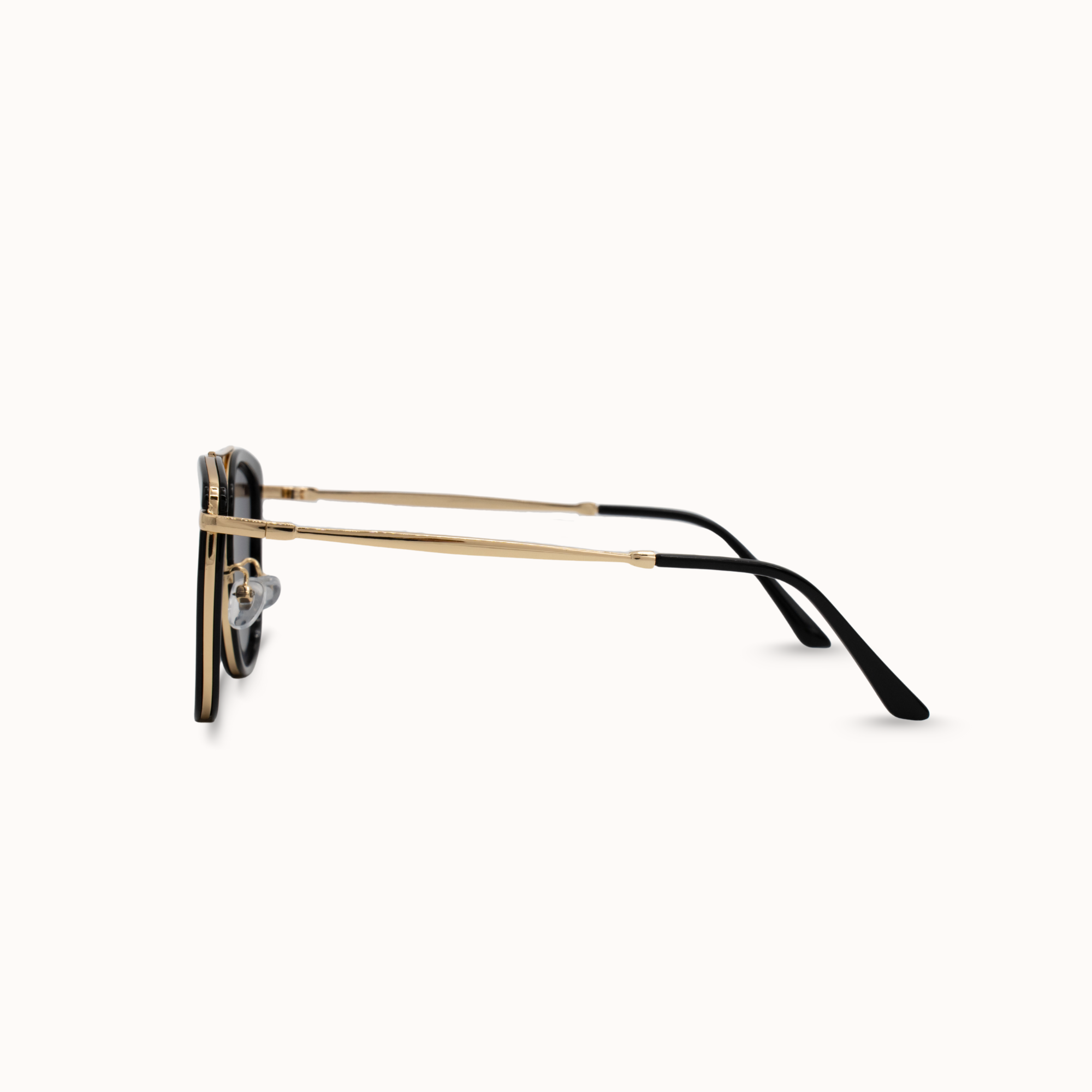 Sunglasses with gold frame and black arms on a white background