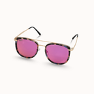 Sunglasses with pink lenses and gold frame on a white background