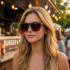 Woman wearing sunglasses with a burger truck in the background