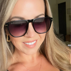 Woman wearing black sunglasses with a blurred indoor background