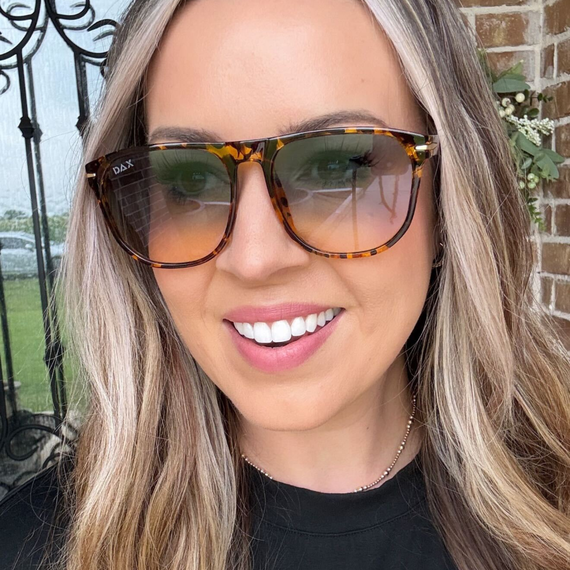 Woman wearing tortoiseshell sunglasses with a blurred background