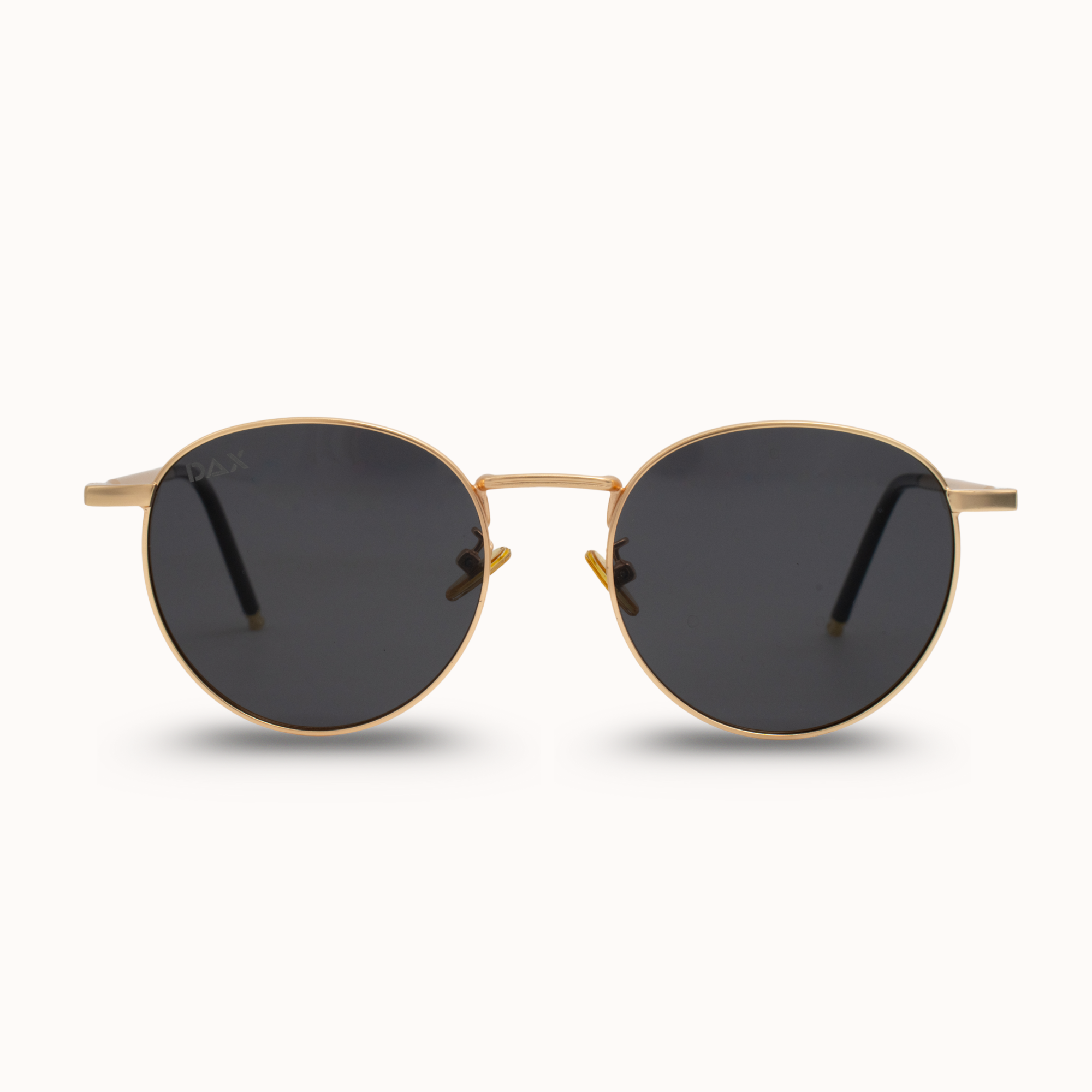 Gold-framed sunglasses with dark lenses on a white background