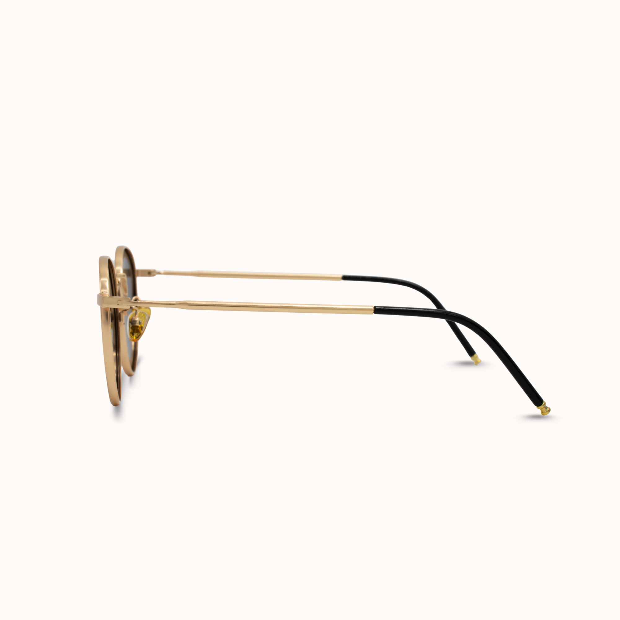 Sunglasses with gold frame and black arms on a white background