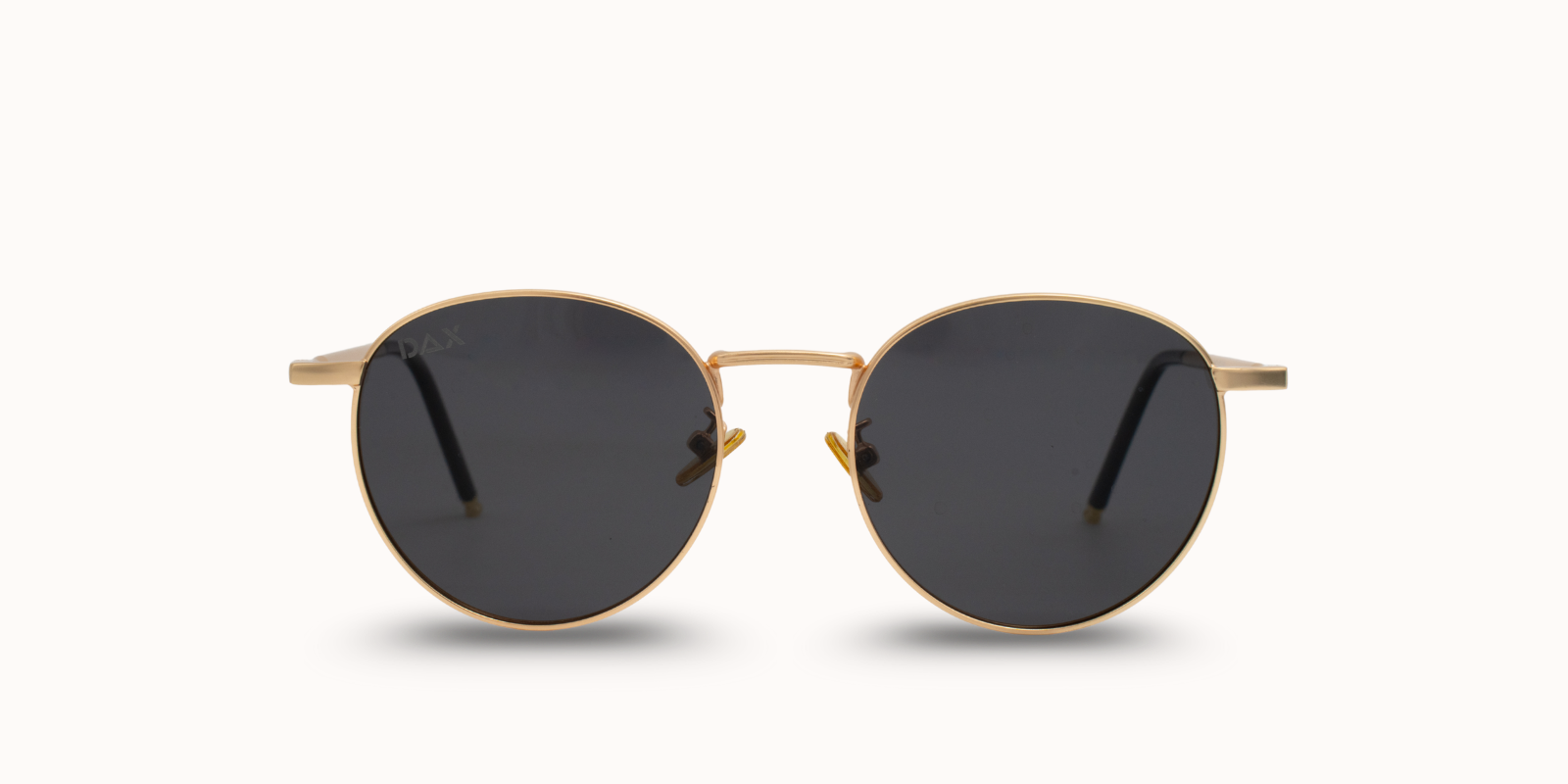 Round sunglasses with gold frame and dark lenses on a white background