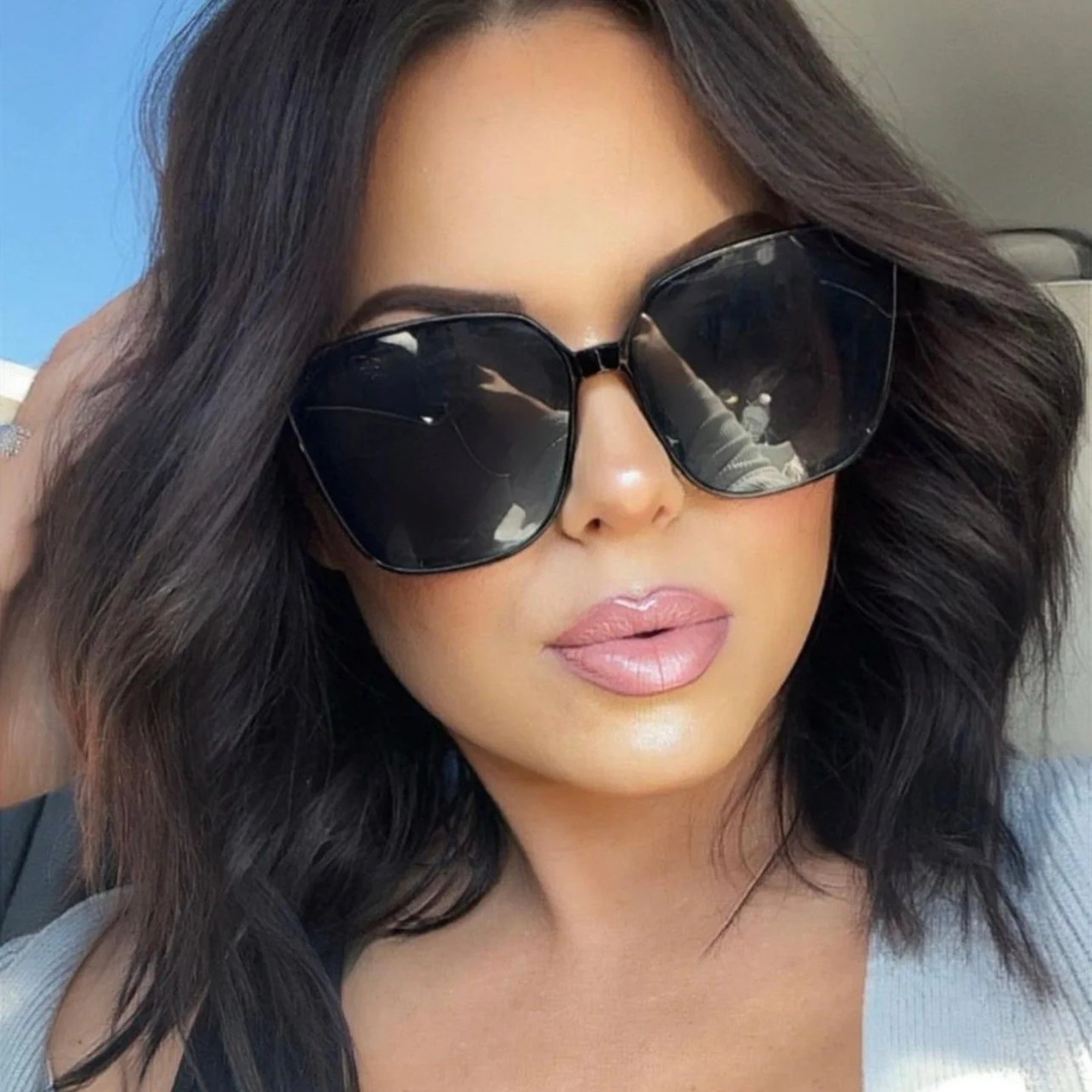 Woman wearing large sunglasses with a blurred background