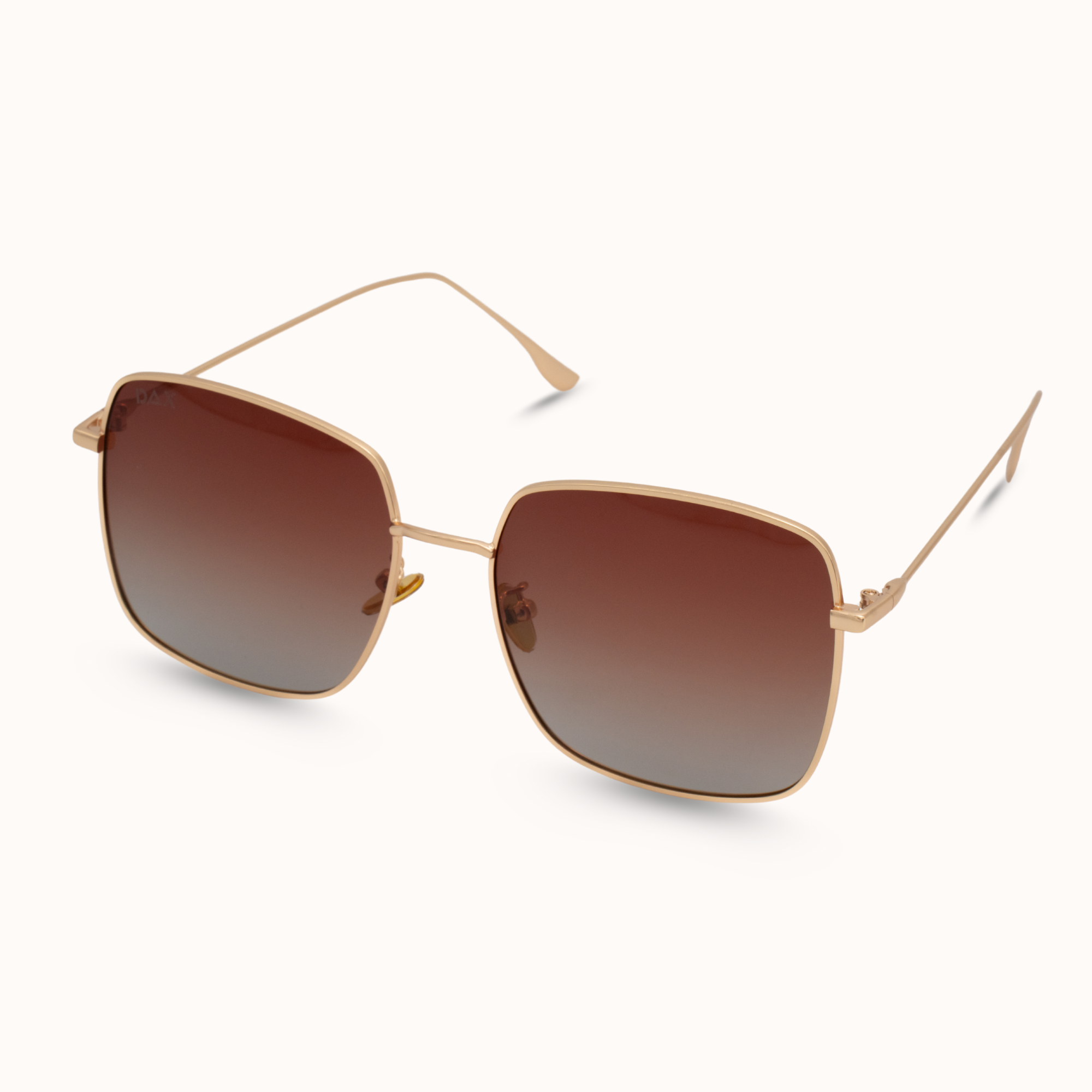 Gold-framed sunglasses with brown gradient lenses on a white background