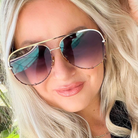 Close-up of a person wearing large sunglasses with a blurred background