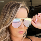 Woman wearing heart-shaped sunglasses with a blurred background