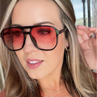 Woman wearing large sunglasses with a blurred background
