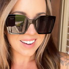 Woman wearing DAX sunglasses with a blurred background