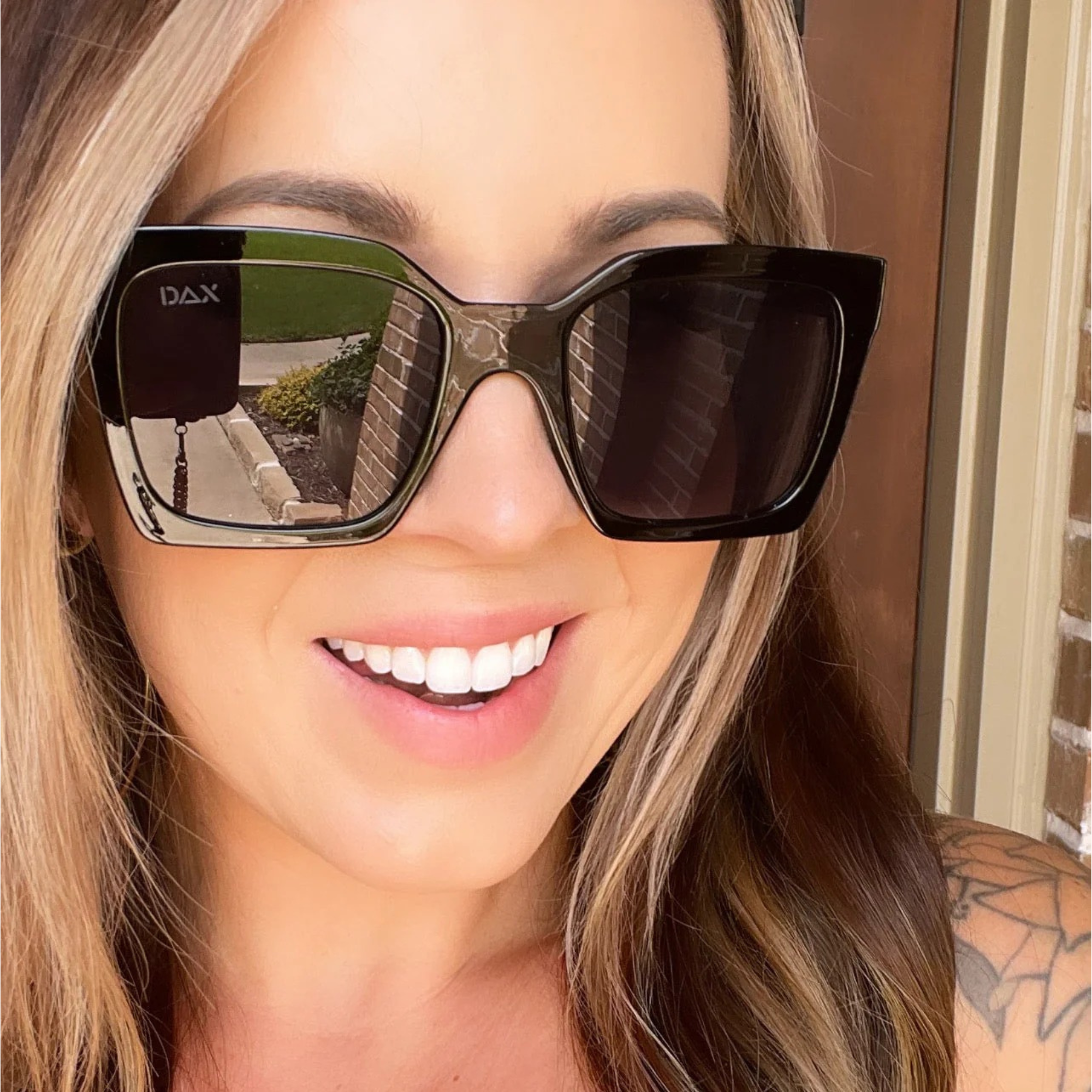 Woman wearing DAX sunglasses with a blurred background