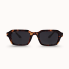 A pair of D&X square sunglasses with a dark brown and black tortoiseshell frame and dark lenses, shown against a plain off-white background.